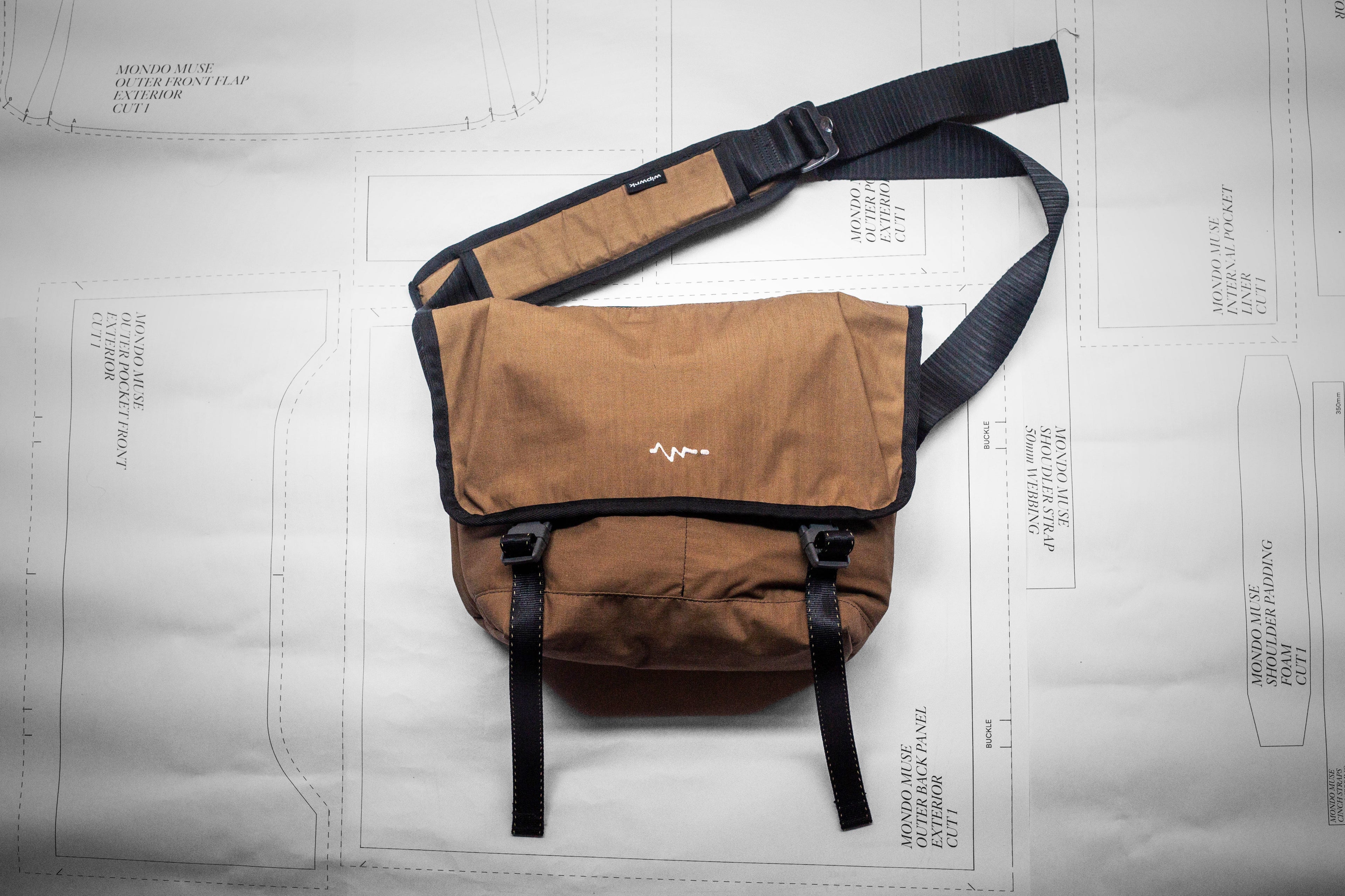 Brown bag with black strap on a white background